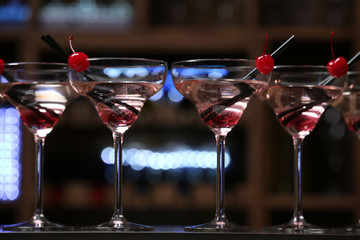 Glasses of cocktails on bar background