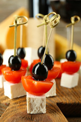 Cheese canapes with wine on table close up