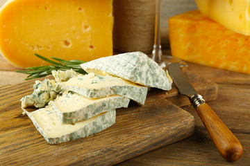 Slices of tasty blue cheese on cutting board close up