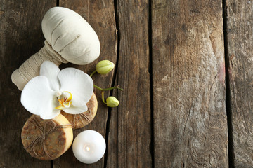 Fototapeta na wymiar Still life with beautiful blooming orchid flower, spa treatment and pebbles, on wooden background