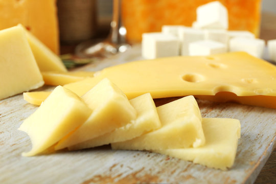 Various types of cheese on cutting board close up
