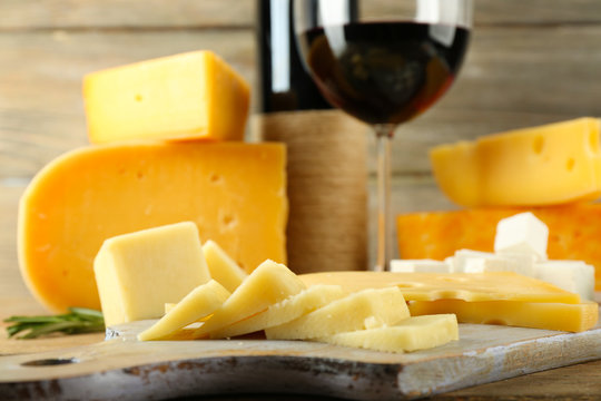 Various types of cheese with wine on table close up