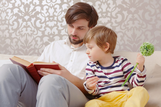 Father and son read a book