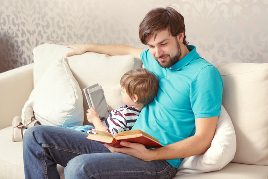 Father and son read a book or tablet