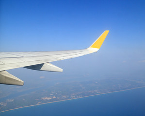 Wing of an airplane flying above sky