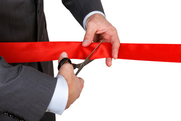 Businessman in suit cutting red ribbon with pair of scissors iso