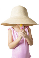 Child with hat eats ice cream in studio