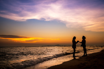 Fototapeta na wymiar Silhouette female standing on the sunset beach