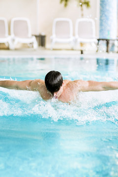 Muscular handsome male swimming in a pool