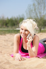 Naklejka premium Glücklioche Frau telefoniert am Strand