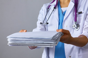 Young female doctor giving a stack of documents