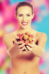 Nude woman holding litchi