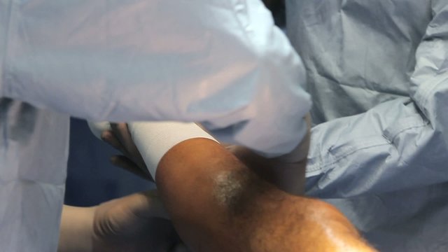 Surgery. Wrapping leg with elastic bandage.