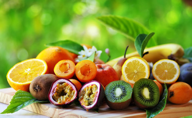 Fruits with leafs on table on green background