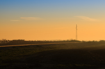 Fototapeta na wymiar Power lines by the railway at sunset