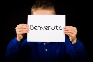 Child holding sign with Italian word Benvenuto - Welcome