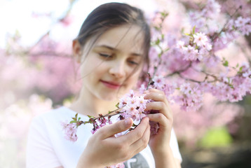 Wiosna to piękna pora roku.Dziewczynka w kwiatach wiśni.