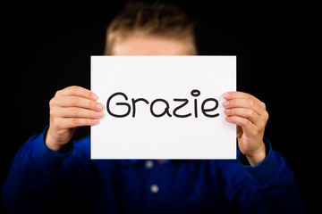 Child holding sign with Italian word Grazie - Thank You