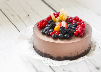 raw birthday cake with berries on a wooden table