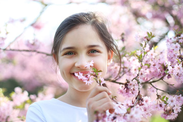Uwielbiam wiosnę ! Dziewczynka wącha kwiaty wiśni