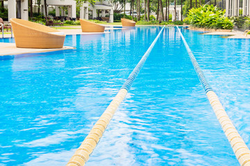 Swimming path in nice blue swimming pool and round resting chair