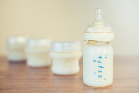 Baby bottle with milk and a measuring scale