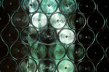 Fototapety  Ściana szklanych butelek z czymś metalowym za nią. Selektywny