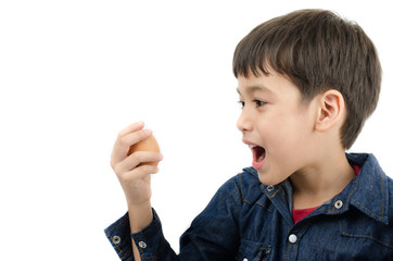 Little boy holding egg in hand mouth wide healthy on white backg