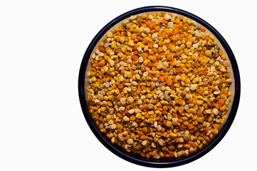 Raw organic bee pollen in a glass. Isolated on white