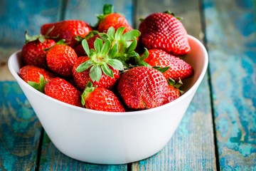 Fresh ripe organic strawberries in a white bowl