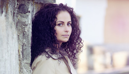 Fototapeta premium Charming young woman in white jacket in old city.