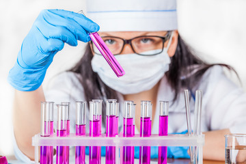 laboratorian inspects the contents of the test tubes closeup