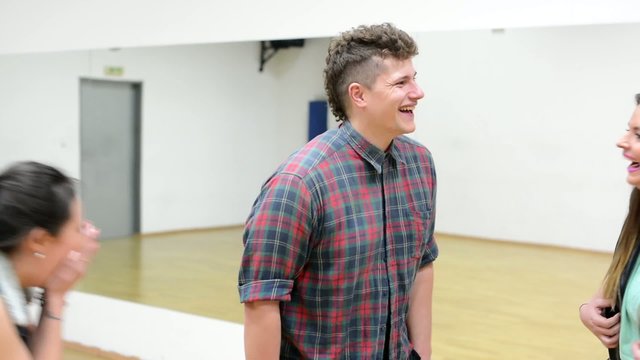 A group of young friends (dancers) laugh to camera- hall