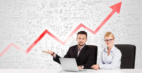 Business man and woman sitting at table with market diagrams