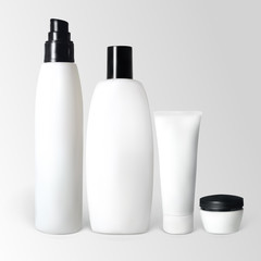 Set of cosmetic products in bottles and tubes.