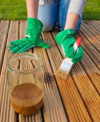 Applying protective varnish on a patio wooden floor