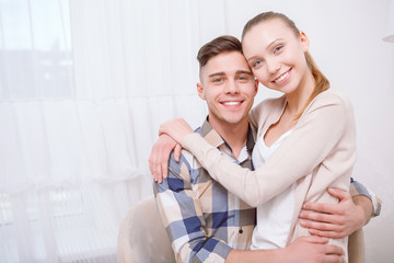 Young lovely couple sitting and hugging