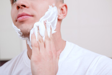 Naklejka premium Young handsome man shaving