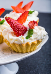 Delicious cupcake with whipped cream and fresh strawberries