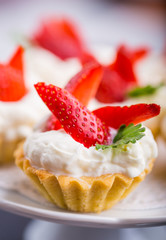 Delicious cupcake with whipped cream and fresh strawberries