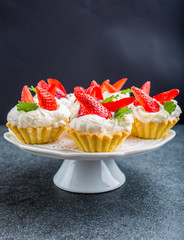 Delicious cupcake with whipped cream and fresh strawberries