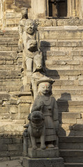 Fototapeta na wymiar Statues on the steps of an ancient temple in Bhaktapur, Nepal