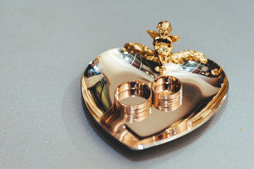 Golden wedding rings on the gold plate heart design.