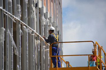 obreros trabajando encima de un andamio