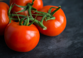 Tasty and fresh tomatoes on a black stone serving board