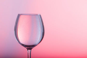 Glass of water on a pink background