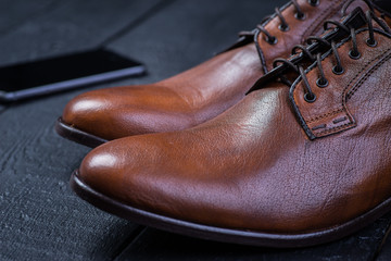 Brown leather shoes on black floor