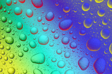 Abstract background, colored water drops on transparent surface