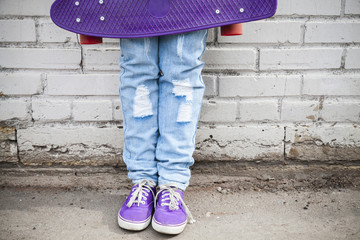 Teenager feet in blue jeans with skateboard