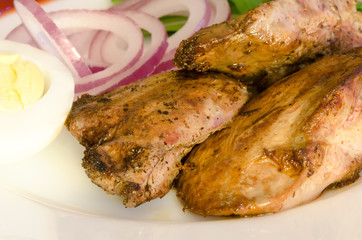 Roasted chiken liver with vegetables on white plate